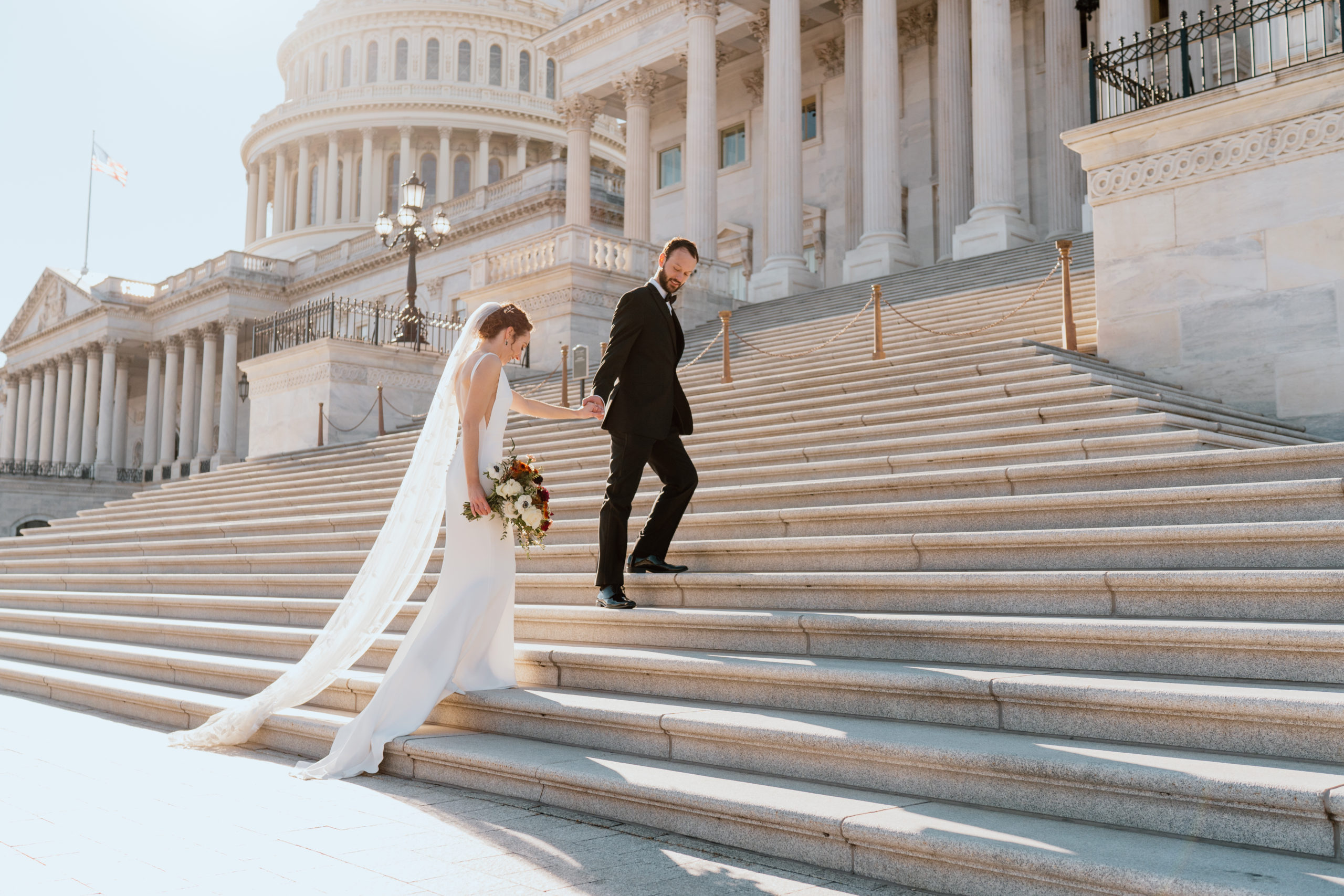 Bride and Groom walking up Capitol Building steps on their wedding day in Washington DC in Capitol Hill